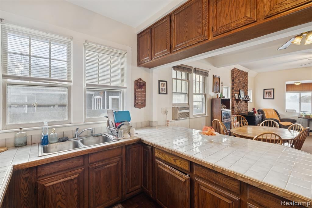 Kitchen with tile countertops and wood cabinetry