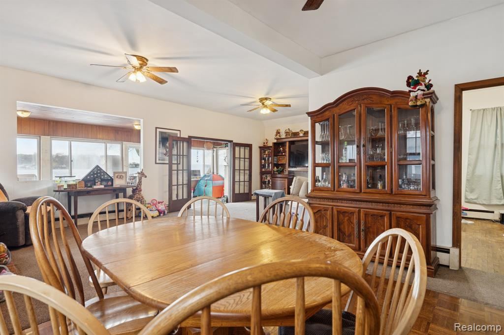 Dining area with a ceiling fan and lake-facing windows