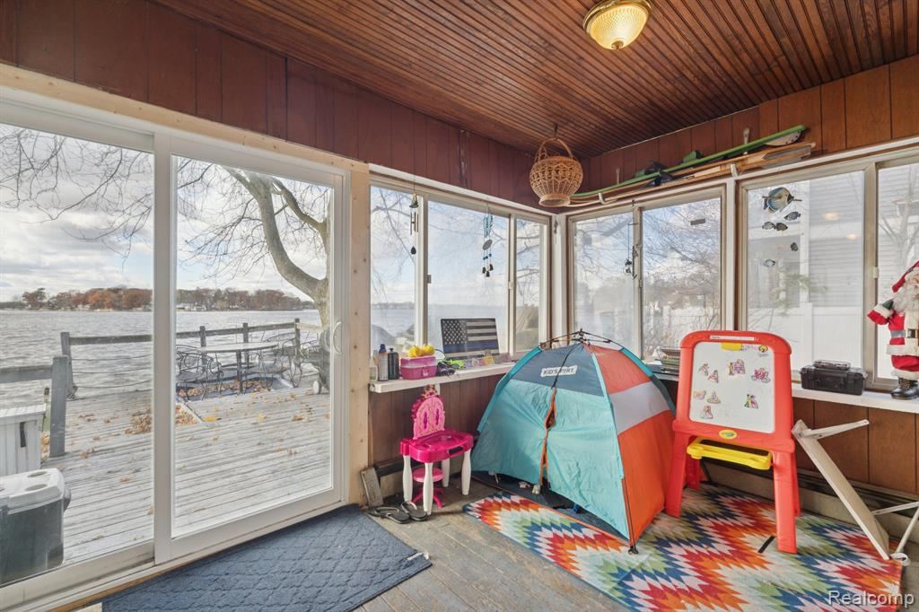 Sunroom with wood walls and a view of the water