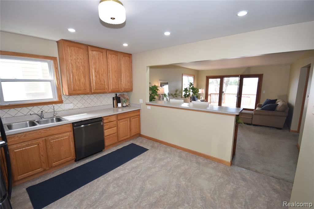Open kitchen with light countertops and a view into the living area