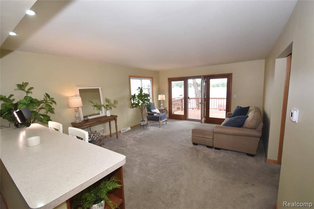 Living area with recessed lighting and doors to the deck
