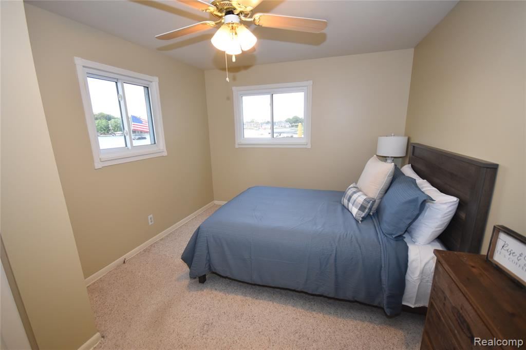 Bedroom with a ceiling fan and two windows
