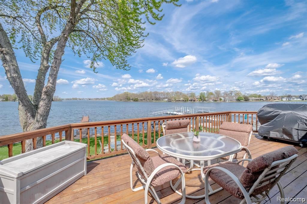 Wooden deck with outdoor dining and grilling space overlooking the lake